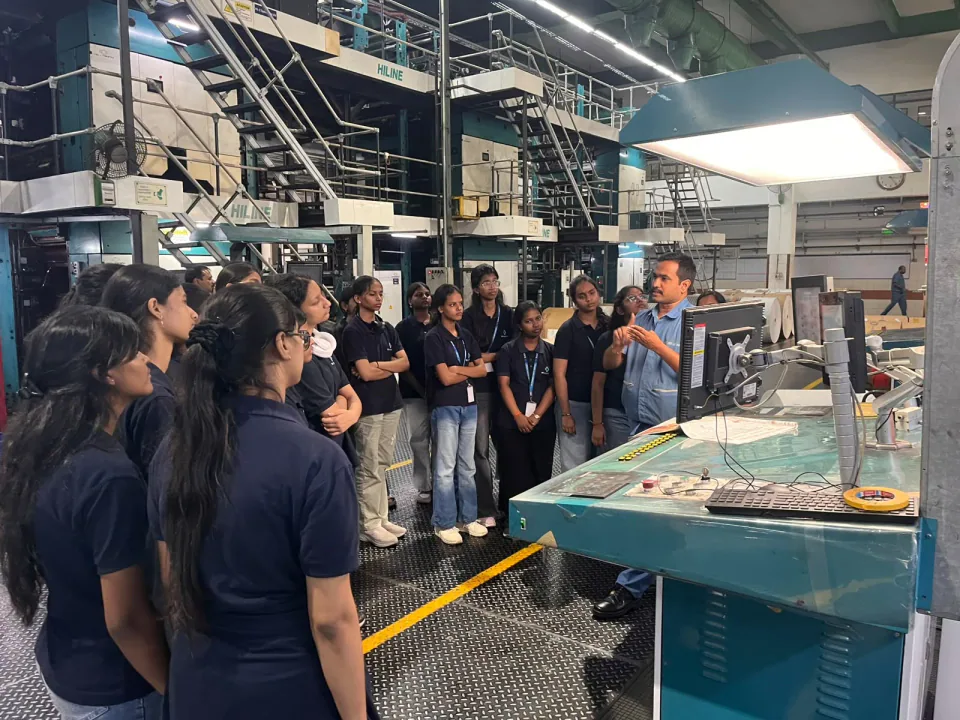 Students learning about newspaper printing on a press visit